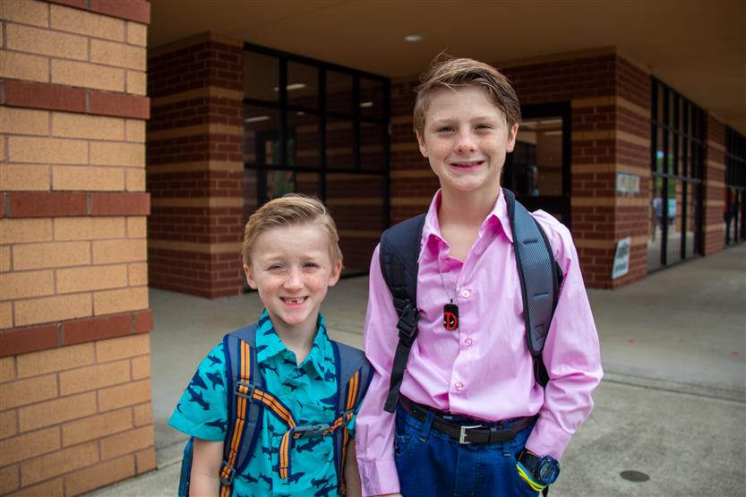 Two students smile while standing in front of Westwood Elementary